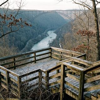 Bare winter forest on a sandstone rim above a deep river gorge in West Virginia